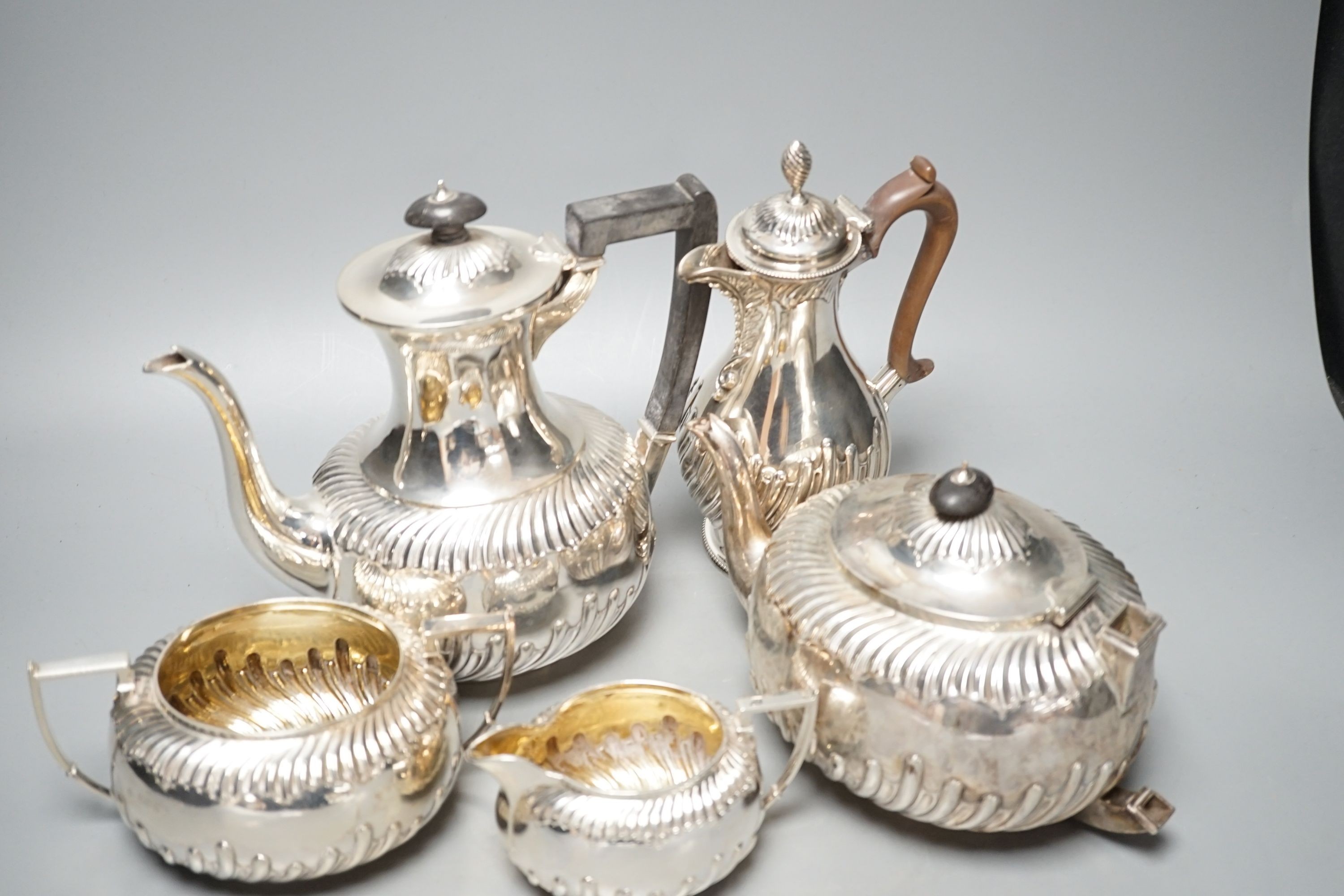 A late Victorian repousse silver four piece tea set, Martin, Hall & Co, Sheffield, 1892, (a.f.) together with a Victorian silver hot water jug, Charles Stuart Harris, London, 1884, gross 60.5oz.